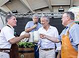 Drei Männer stoßen mit Bierkrügen an