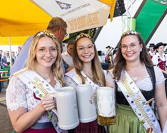 Drei Hopfenprinzessinnen mit Bierkrug in der Hand