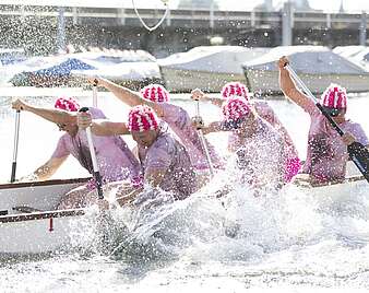 Drachenboot-Cup: Mannschaft paddelt, Wasser spritz