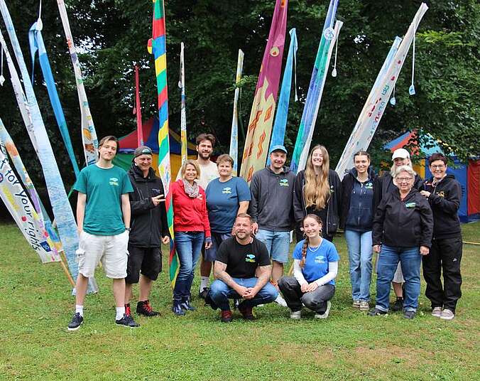 Menschengruppe vor bunten Fahnen
