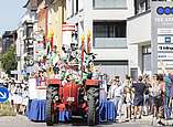 Festzug: Wagen gezogen von Traktor mit Mann in Hasenkostüm darauf