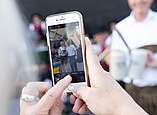Smartphone macht Foto, im Display Menschen