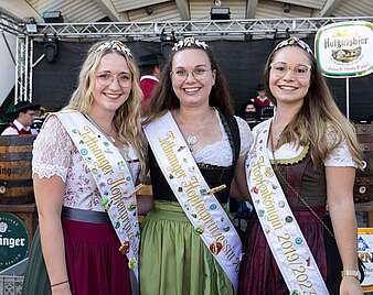 Gruppenbild: Drei Tettnanger Hopfenprinzessinnen mit Dirndl, Schärpe und Diadem