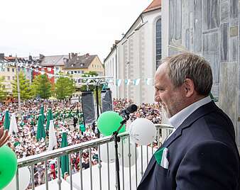OB Blümcke auf dem Rathausbalkon mit Blick auf den Adenauerplatz, auf dem Erstklässler auf den Seehas warten
