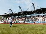 Mädchen spielen Fußball Zuschauer im Hintergrund auf Tribüne