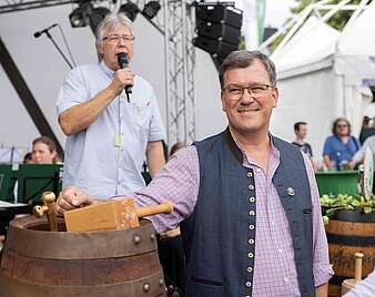 Mann moderiert einen Fassanstich