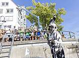 Mann in Hasenkostüm vor Ufermauer mit Menschen