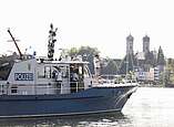 Mann in Hasenkostüm steht auf Polizeiboot und Wink, im Hintergrund Schlosskirche