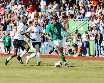 Jungs spielen Fußball Zuschauer im Hintergrund auf Tribüne
