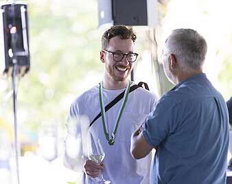 Männer unterhalten sich, einer davon mit Seehasen-Medaille