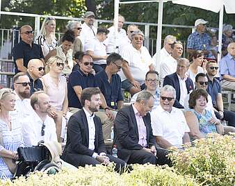Festzug: Ehrentribüne mit Menschen