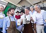 Gruppenbild: Männer mit Bierkrügen in der Hand nach Fassanstich