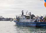 Polizeiboot fährt mit Menschen auf See