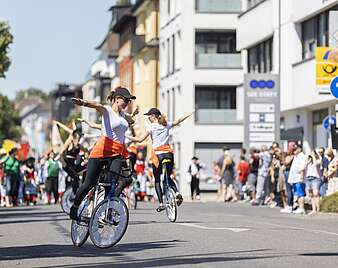 Festzug: Kinder machen Kunststücke auf Fahrrädern
