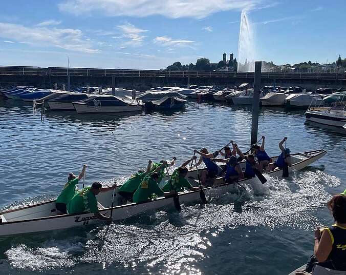 Drachenboot im Wasser mit zwei Teams und Publikum am Hafen