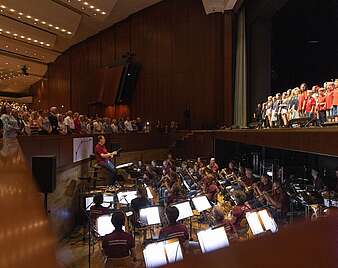 Kinder spielen Theater auf Bühne, Orchester im Vordergrund