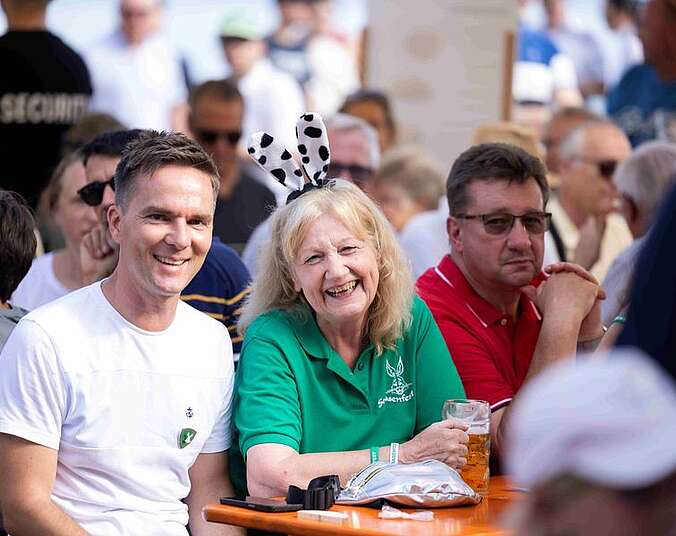 Menschen feiern an Biertischen