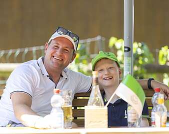 Mann und Kind lachen in Kamera