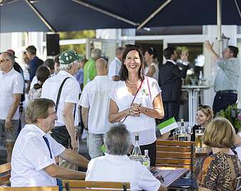 Menschen feiern bei Stehempfang in Biergarten