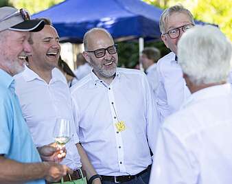 Menschen feiern bei Stehempfang in Biergarten