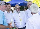 Menschen feiern bei Stehempfang in Biergarten