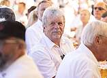 Menschen an Biertischen, Mann schaut in Kamera