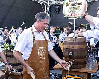 Mann sticht Bierfass an