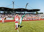 Fanfarenzug mit Fahnenschwinger auf Fußballplatz
