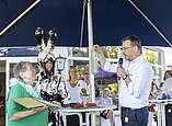 Ehrung von Frau von Mann in Hasenkostüm, weiterer Mann spricht in Mikrofon