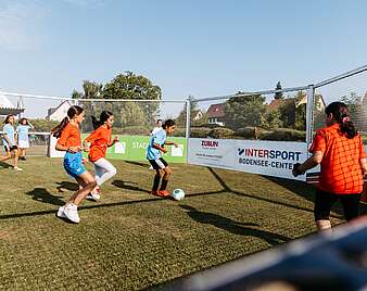 Fußballkäfig: Mädchen spielen Fußball in Oktagon